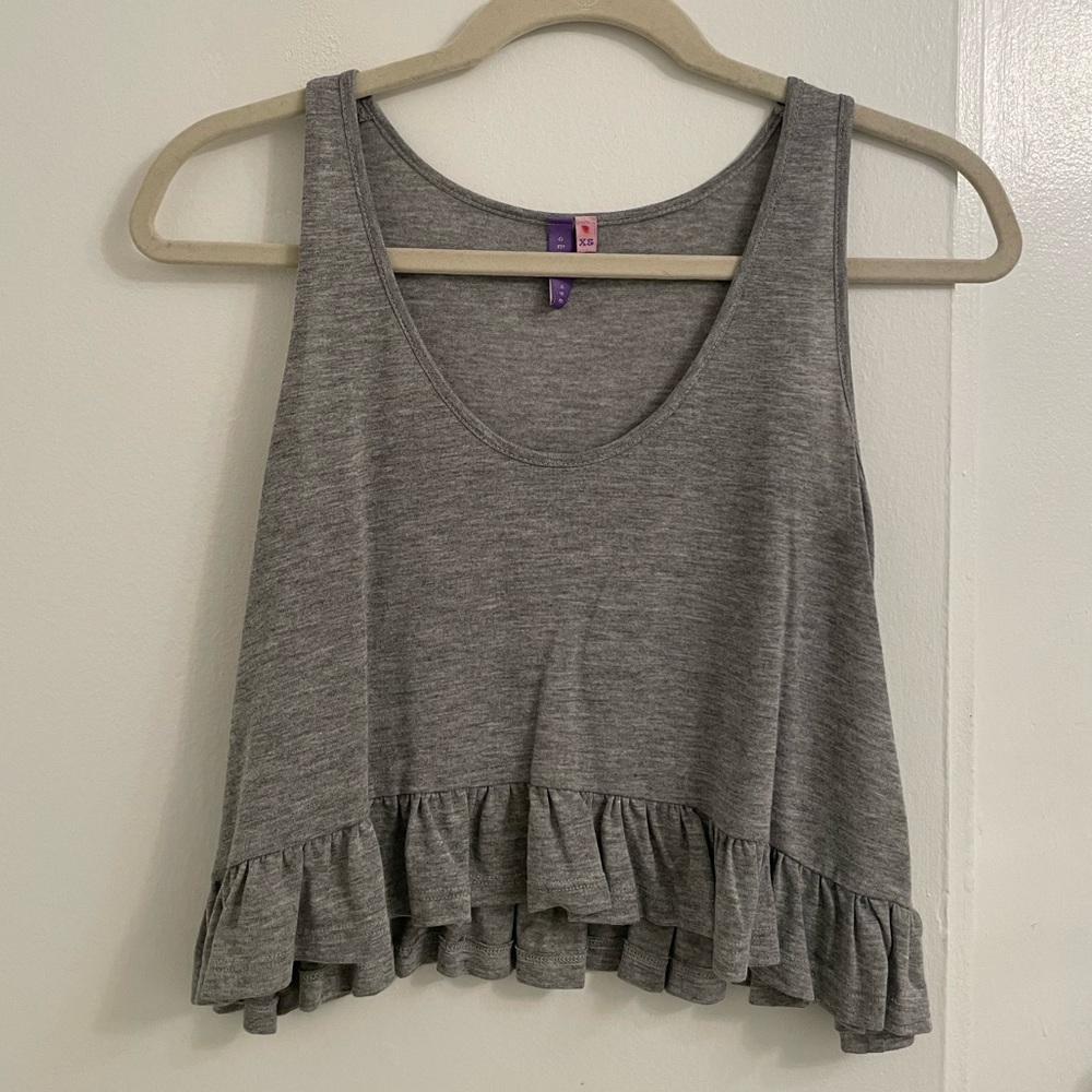 Cropped grey tank top with ruffle bottom.